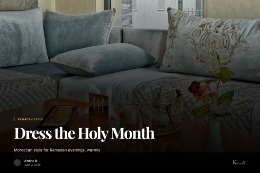 A softly lit Moroccan living room with a pink pompom blanket draped over a cushioned sofa, brass lanterns
