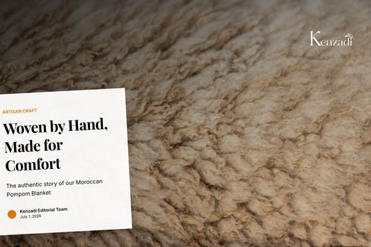 A close-up detail of a handmade striped brown blanket with white pom poms, showcasing the texture and craft