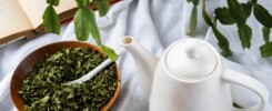 a cup of tea next to a bowl of tea and a book