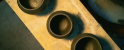 three brown bowls sitting on top of a wooden table